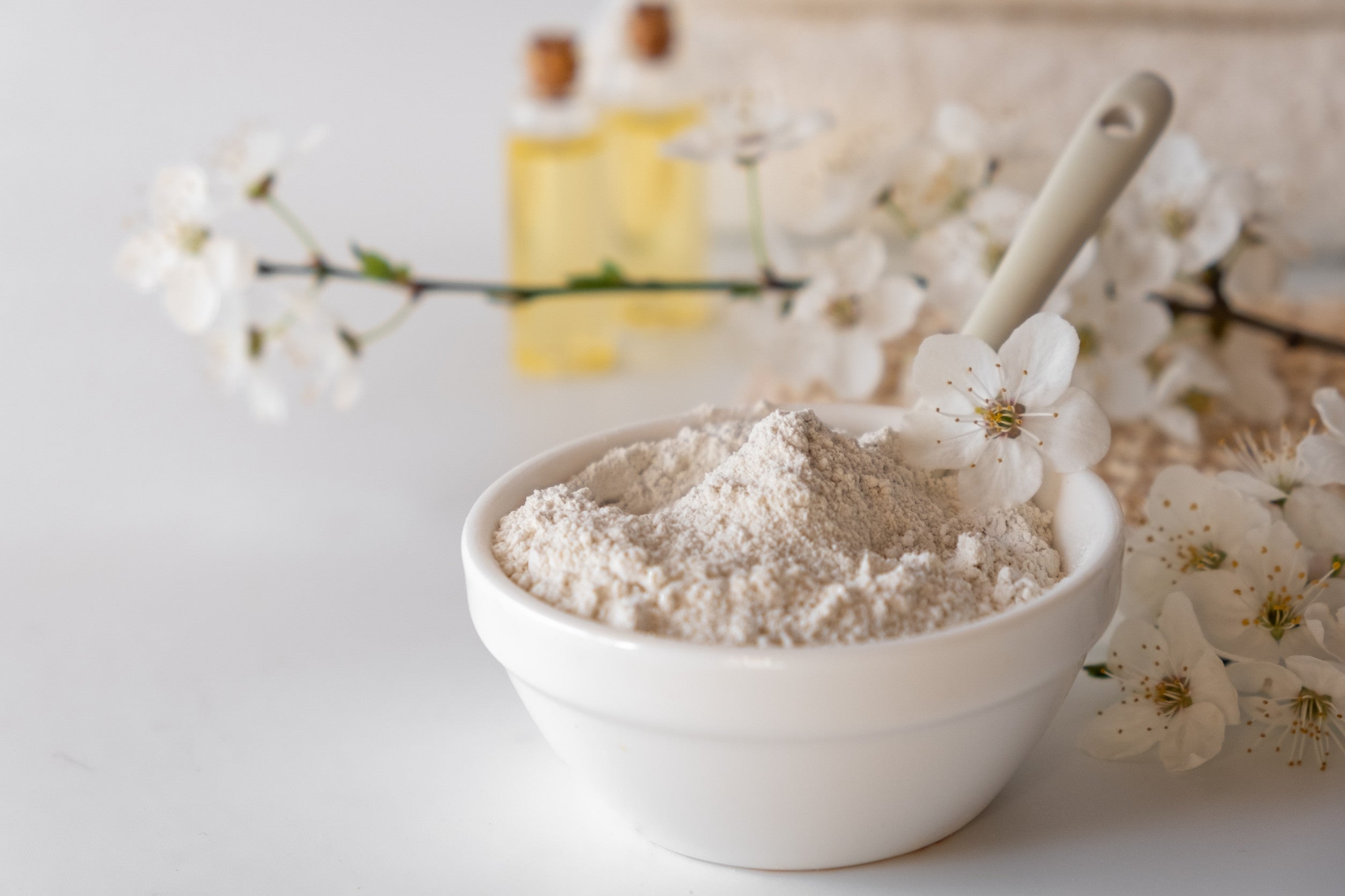 Ceramic bowl with white clay powder on white background