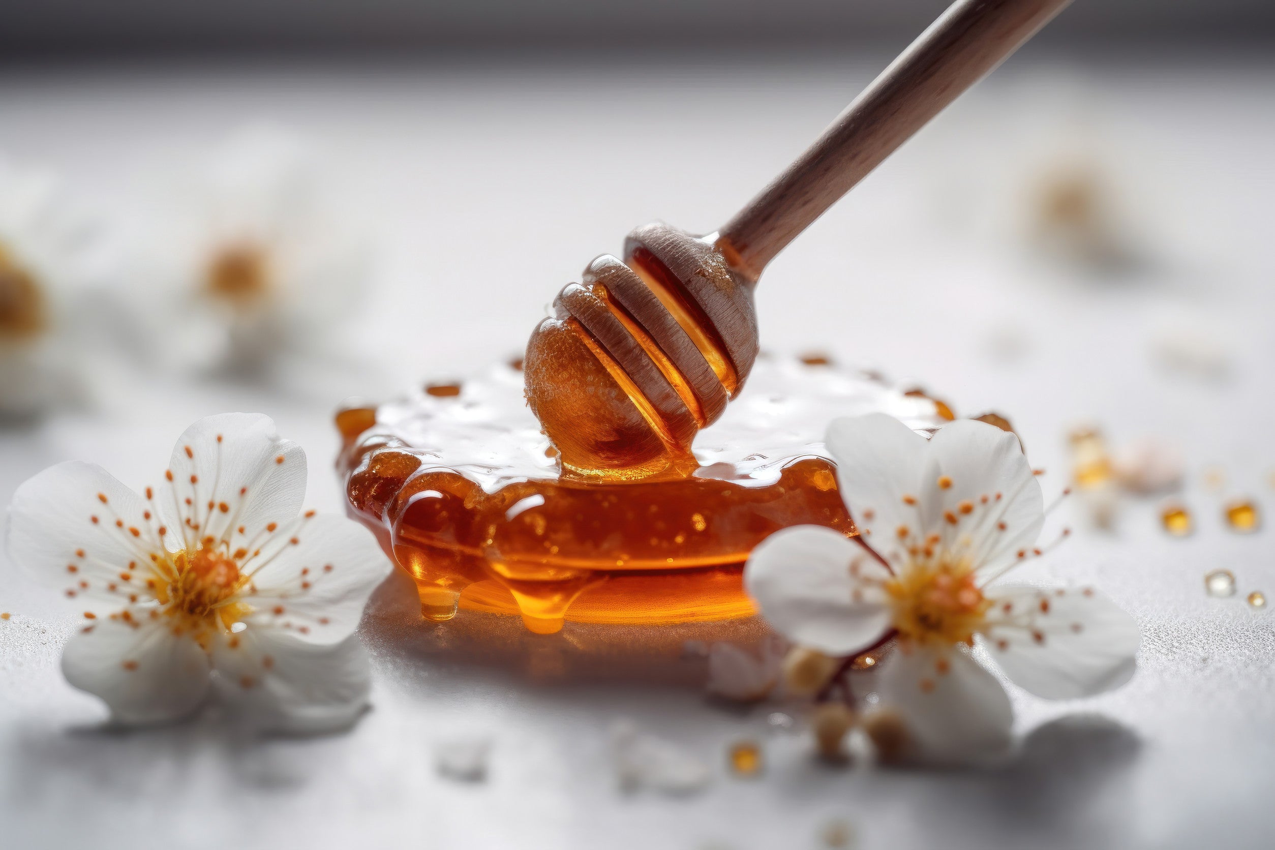 Manuka honey with honey dipper and flower