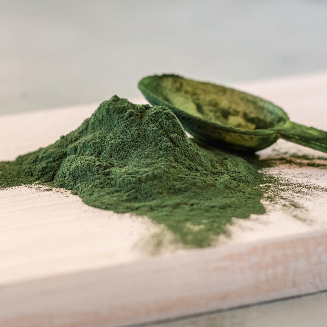Fine green powder of Chlorella, a powerful antioxidant and detoxifying ingredient for skincare formulations.