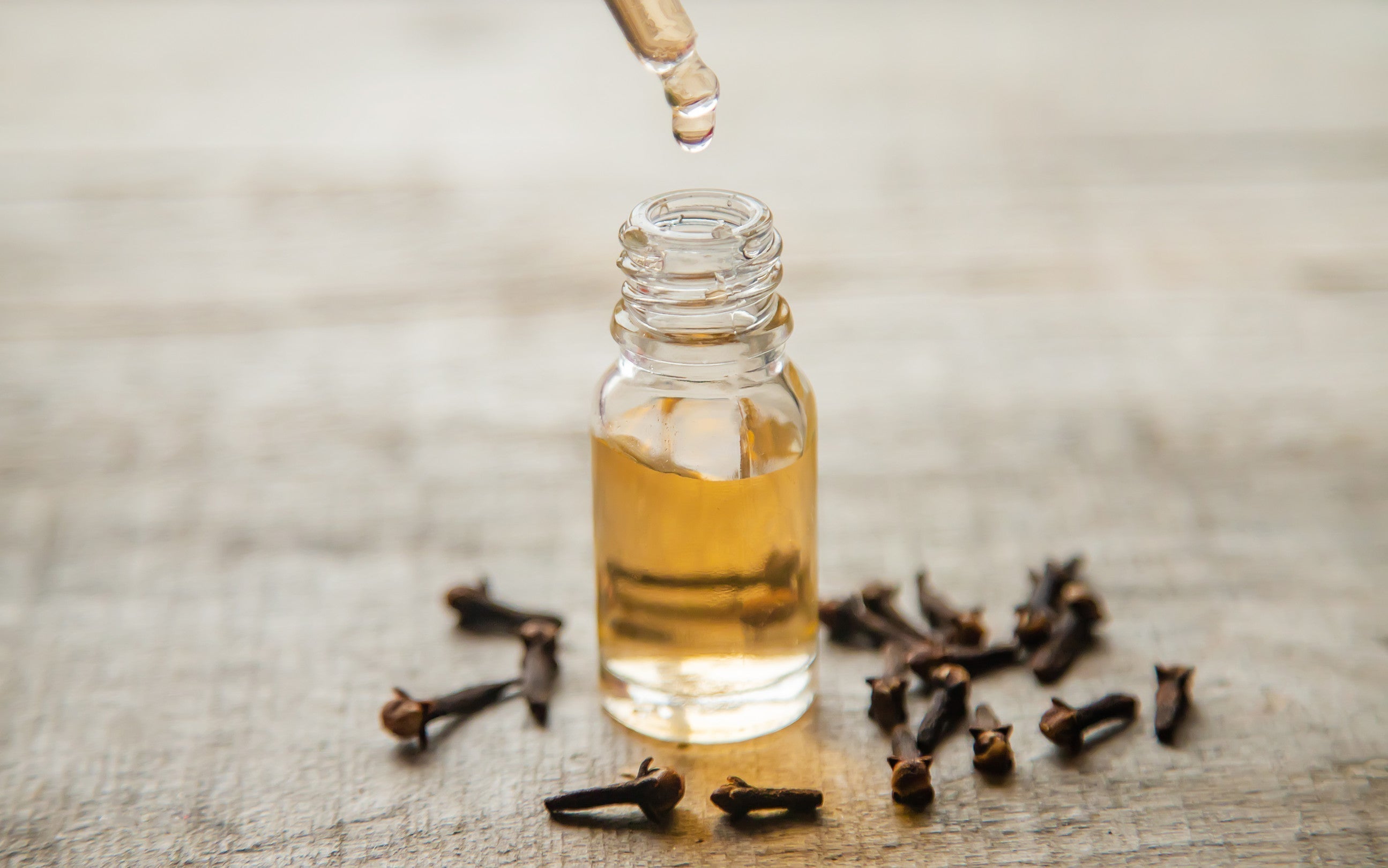 Glass bottle and dropper of clove bud essential oil with cloves