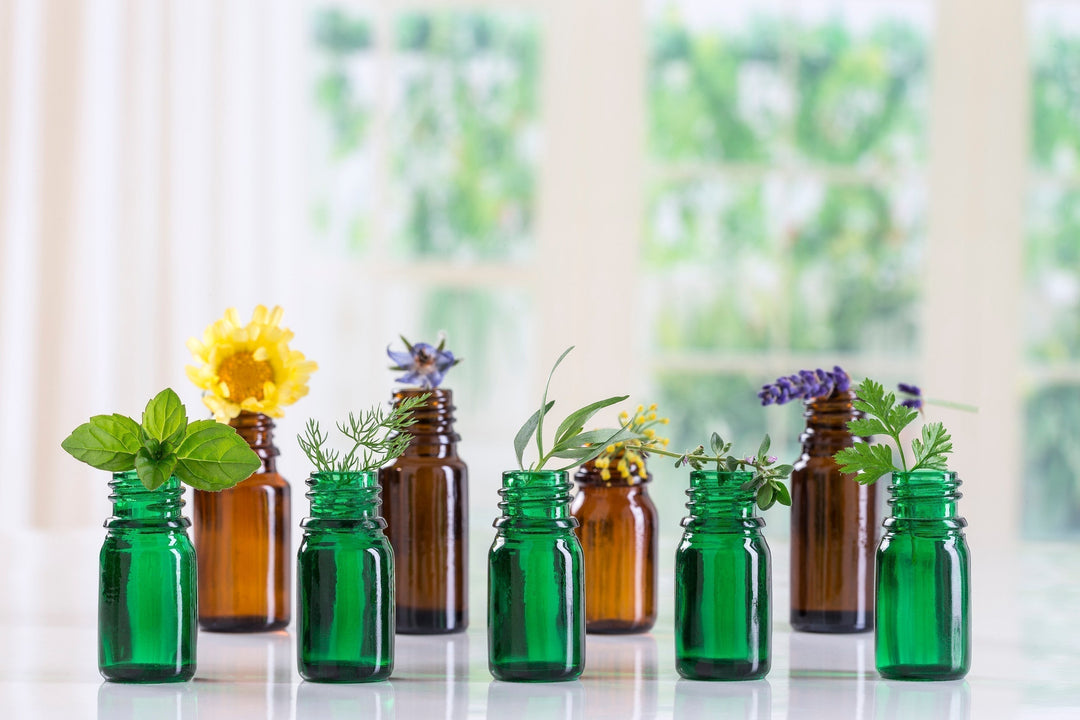 Essential oil bottles with herbs and dried flowers