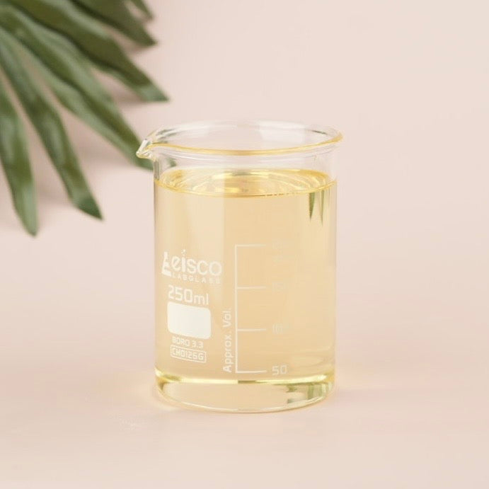 Glass beaker with yellow liquid labeled 'Leisco' on a beige background