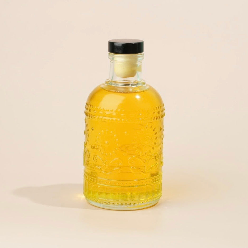 Bottle of yellow liquid with a black cap on a beige background