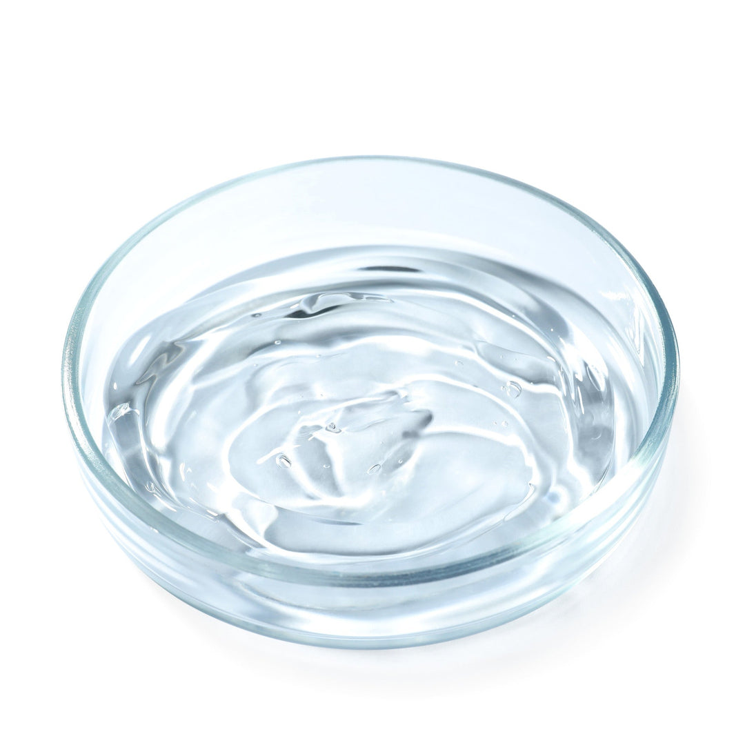 Clear glass bowl filled with water on a white background
