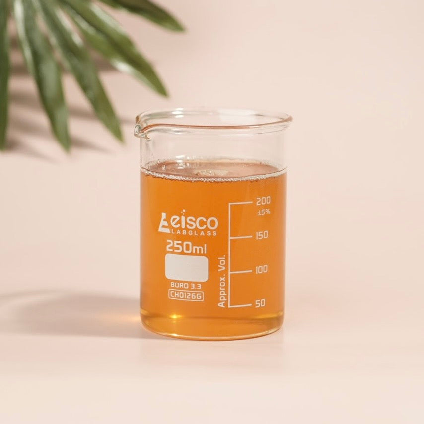 Leisco glass beaker with liquid on a beige background