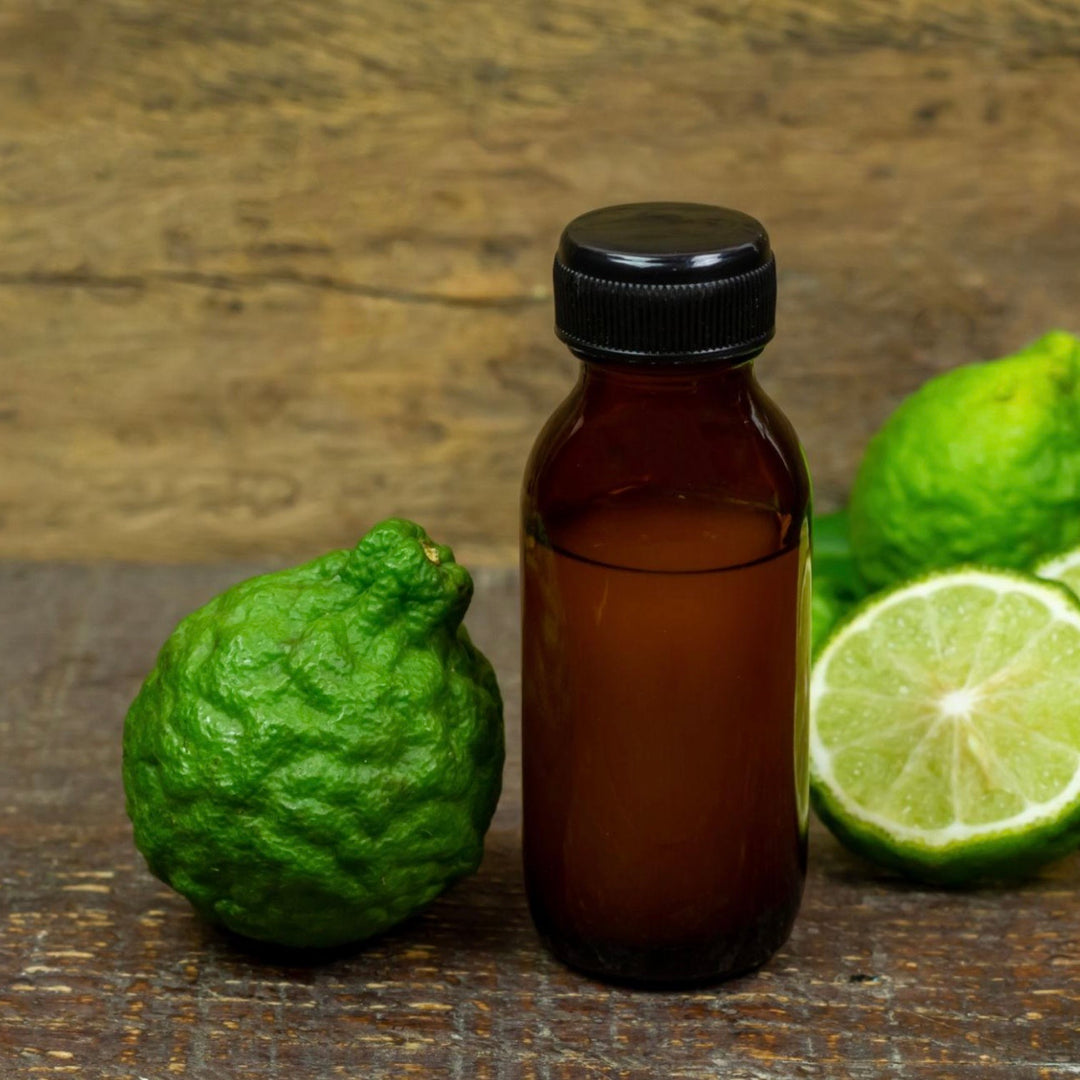 Brown bottle with a black cap on a wooden surface with green limes.