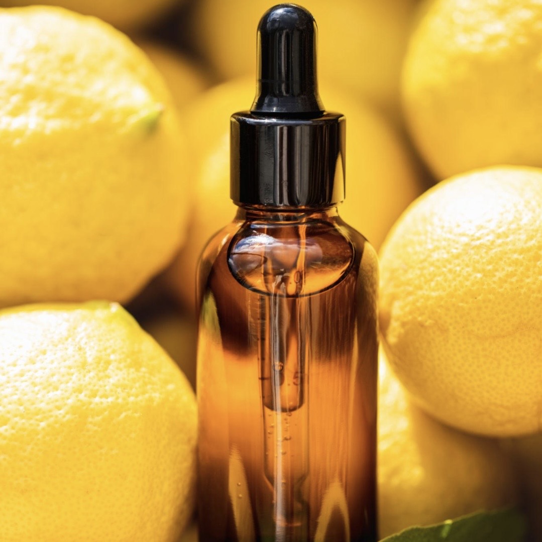 Brown glass dropper bottle with lemons in the background