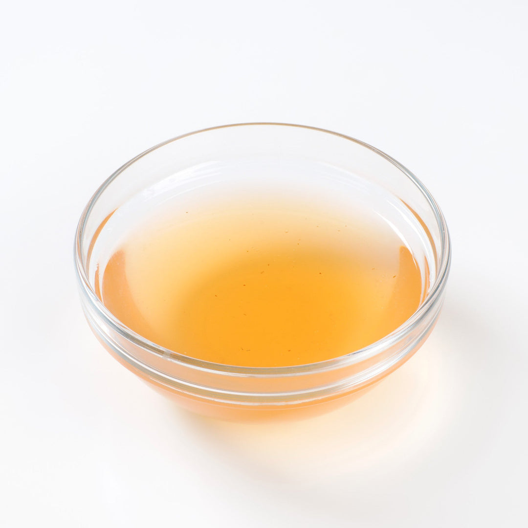 Photo of a yellow liquid in a clear glass bowl.
