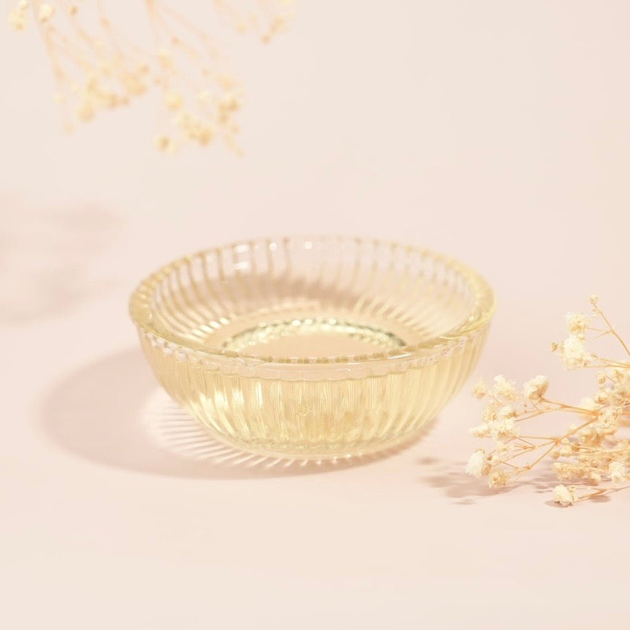 Clear glass bowl on a light beige background with delicate flowers
