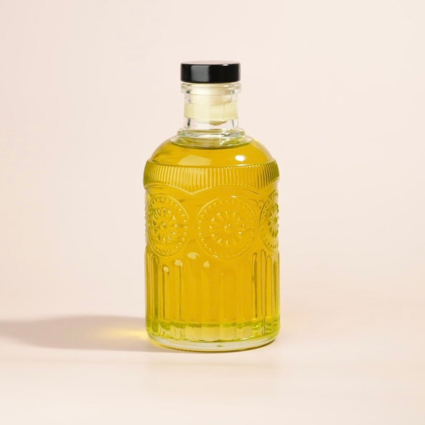 Glass bottle with yellow liquid on a beige background