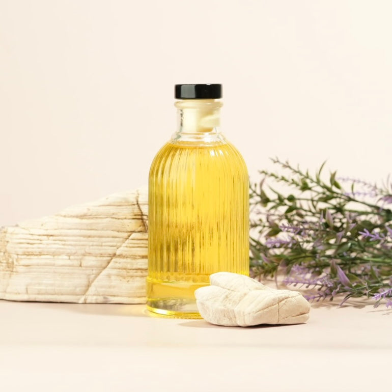 Tan background, white rocks, lavender and a decorative glass bottle