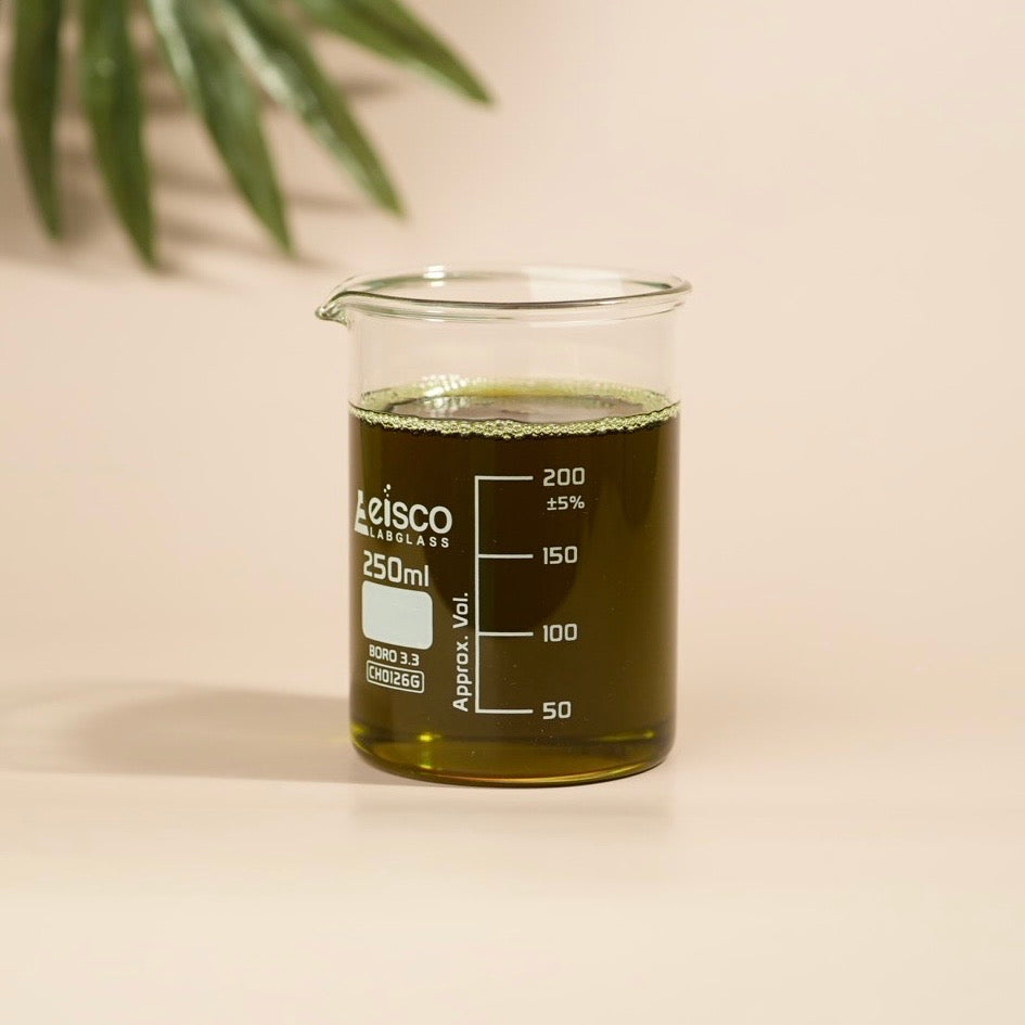 Beaker with green liquid and Leisco Laboratories branding on a beige background