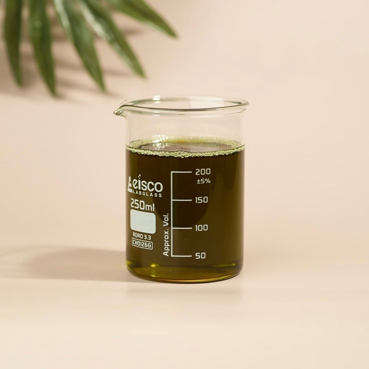 Beaker with green liquid and Leisco Laboratories branding on a beige background