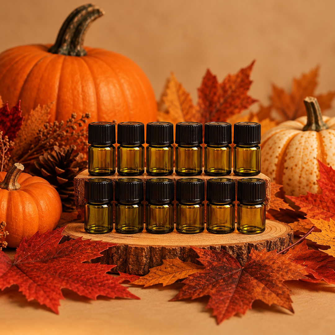 Twelve amber glass 1ml vials of fragrance oil with pumpkins and fall leaves in the background