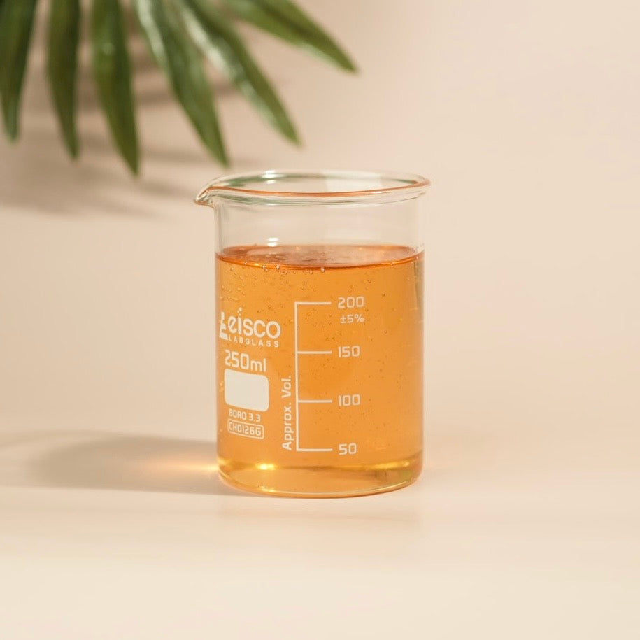Leisco beaker with orange liquid on a beige background