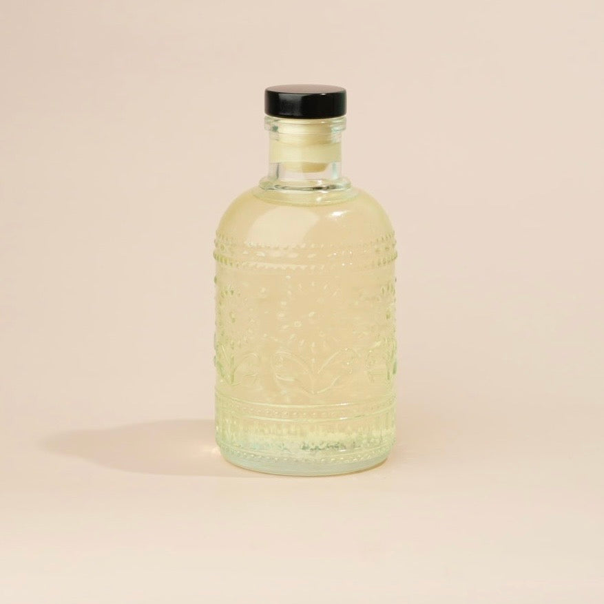 Glass bottle with textured design on a beige background