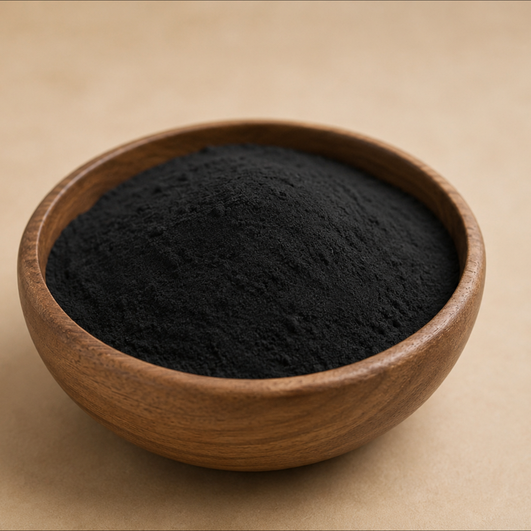 Wooden bowl filled with black powder on a beige background