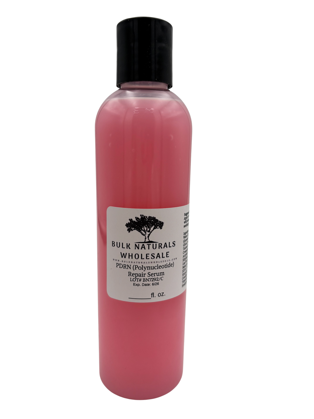 A clear bottle of pink face serum.