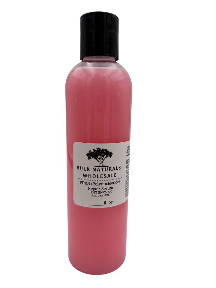 A clear bottle of pink face serum.